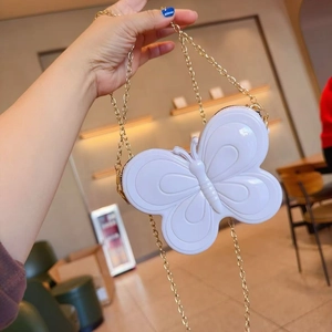 Vue détaillée du sac à bandoulière blanc en forme de papillon avec chaîne en métal doré