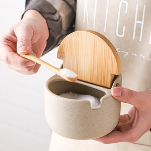 Japanese ceramic seasoning jar with bamboo lid and spoon, set against kitchen background