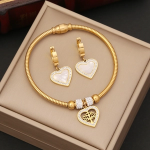 Gold jewelry set featuring a tree of life heart pendant bracelet and matching earrings