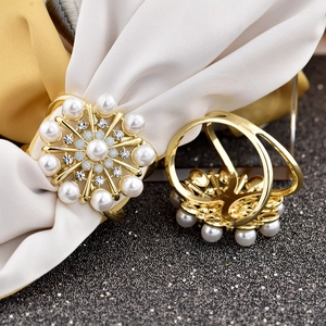 Detail of golden flower napkin ring featuring white pearls and sparkling rhinestones
