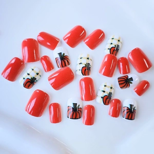 Faux ongles carrés courts avec finition orange et motifs de citrouille festifs