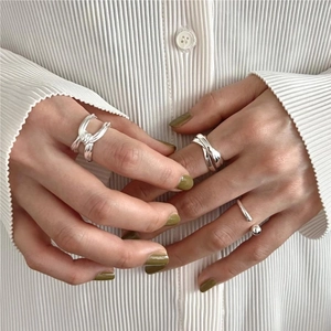 Detail view of minimalist S925 sterling silver knotted ring set worn by a model