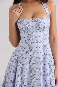 Detail of light blue floral dress with bee pattern, white buttons and pocket flaps