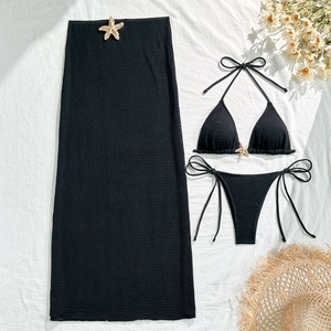 Detailed flat lay of black waffle bikini set with golden starfish buckles and mesh skirt