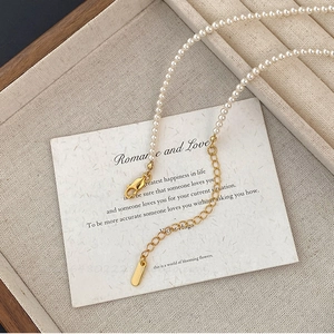 Détail du collier de perles avec fermoir mousqueton doré et chaîne d'extension sur carte