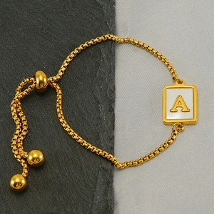 Detail of adjustable slider gold box chain bracelet with white shell letter A pendant