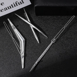 Detailed close-up of four geometric silver hair clips on a textured black background