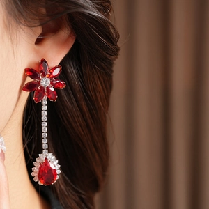 Close-up of red zircon flower drop earrings on a model showing fine jewelry details