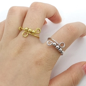 Detail of gold and silver anxiety rings with rotatable beads on a model's hand