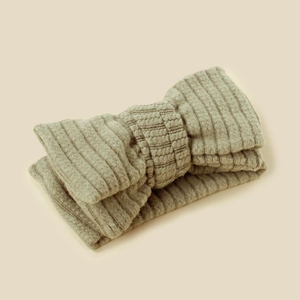 Detailed view of beige ribbed knit baby headband with a soft double-layered bow design