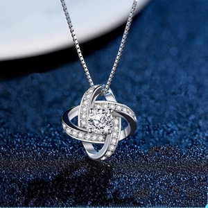 Close-up of S925 silver necklace with sparkling clover knot pendant and central stone