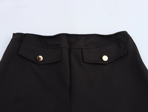 Detailed view of the back waist on black low-rise shorts with metallic button closure