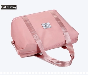 Flat lay of pink waterproof nylon travel bag with durable top handles and zipper closure