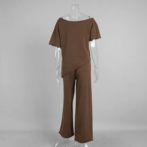 Détail de l'ensemble en tricot avec haut à ourlet asymétrique et pantalon large brun