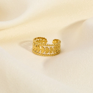 Detail shot of vintage 18K gold leaf ring on luxury silk fabric background