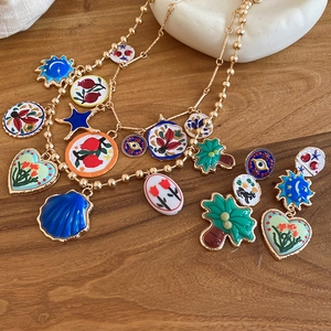 Detail of colorful enamel heart and star charm necklace on a rustic wooden background