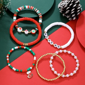 Gros plan de bracelets de Noël en argile polymère rouge et vert avec des perles HO HO HO