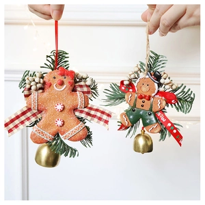 Detail of gingerbread man Christmas ornaments with pine needles and golden bells