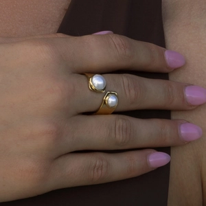 Anello aperto minimalista in acciaio placcato oro 18k con due perle bianche su una modella