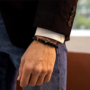 Tiger eye and obsidian bead bracelet with golden letter B charm worn by a man in a suit