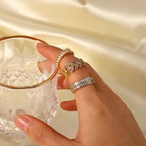 Detailed view of layered 18K gold plated rings with cubic zirconia on fingers