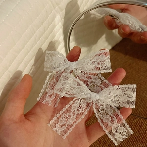 Pair of white lace bow hair clips with delicate floral patterns for sweet ballet style