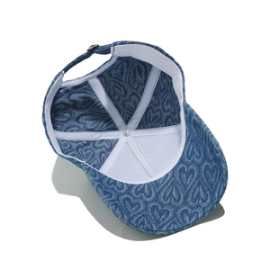 Detail of the adjustable metal buckle and blue denim heart pattern on the baseball cap