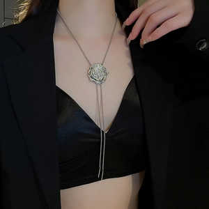 Detail of silver rose pendant with liquid metal texture and zircon on long tassel chain