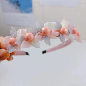Close-up of mesh fabric flowers and pink pearl beads on a sweet style headband