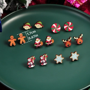 Macro view of Christmas stud earrings set featuring festive characters on a green tray