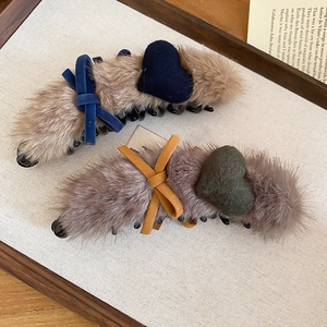 Detailed close-up of plush faux mink fur banana hair clips with heart and bow accents