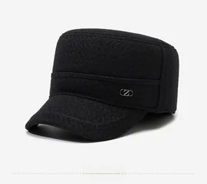 Close-up of black flat top cap showing fabric texture and metal side logo detail