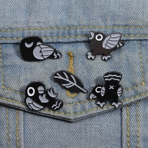 Lot de 5 épingles en émail d'oiseaux punk noirs fixées sur une veste en jean bleu clair