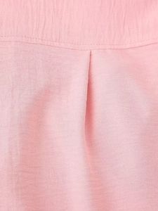 Close-up of pink chiffon fabric showing refined stitching and soft crinkle texture detail