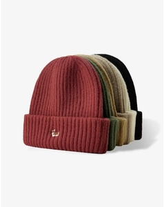Pile of colorful knitted beanies showing fabric texture and cute puppy embroidery details