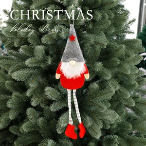 Creative Christmas gnome ornament with red body and gray felt hat on a green tree branch