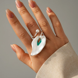 Macro detail of calla lily pearl ring with white enamel petals and green accents