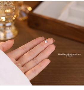 Macro shot of an S925 sterling silver stud earring with a minimalist hollow cross design