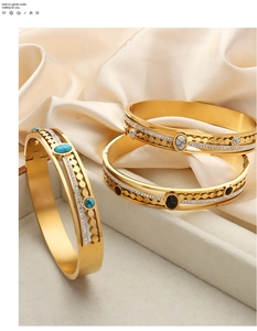 Detail of vintage gold-plated open bangles with turquoise and black onyx insets