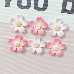 Close-up of pink and white gradient resin cherry blossom ornaments for DIY crafts