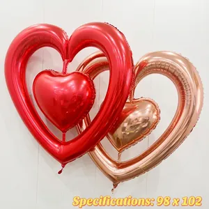 Nested heart-shaped aluminum foil balloons in red and rose gold for festive decoration