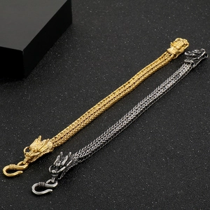 Close-up of vintage stainless steel dragon bracelets with gold and silver bone chain details