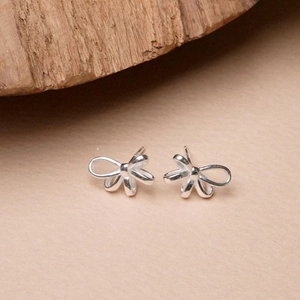 Minimalist S925 sterling silver bow stud earrings for women on a natural wood base