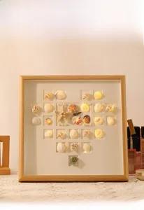 Detail view of heart-shaped natural seashells and warm LED lights in a wood frame