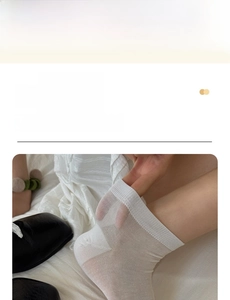 Detail of white semi-transparent mesh socks with ribbed cuffs paired with black leather shoes