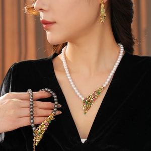 Gros plan sur un ensemble de collier et boucles d'oreilles en perles vintage avec gemmes