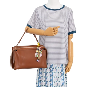 Brown structured handbag with colorful chain tassel charm accessory shown on model