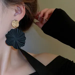 Übertriebene schwarze Blumenohrringe mit goldenem Hammerschlagmetall und Silbernadel