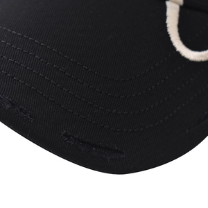 Macro view of distressed brim details and stitching on black cotton cloud baseball cap