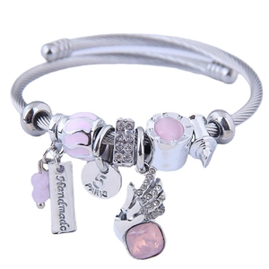 Silver twisted wire bracelet with pink beads, crystal charms and wing pendant